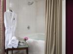 water filled jacuzzi tub with robe and towels